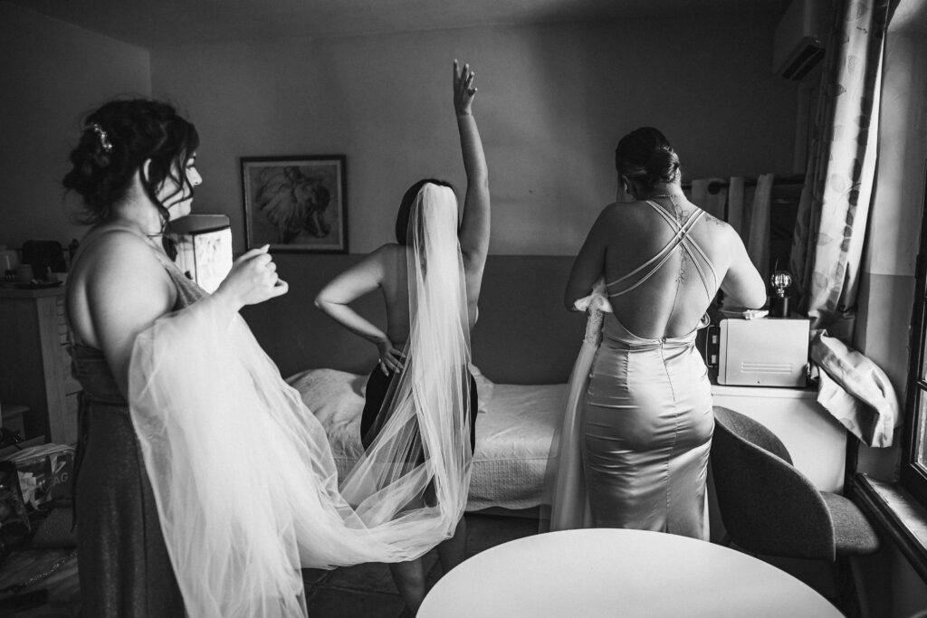 La mariée joue pendant ses préparatifs avec ses témoins.