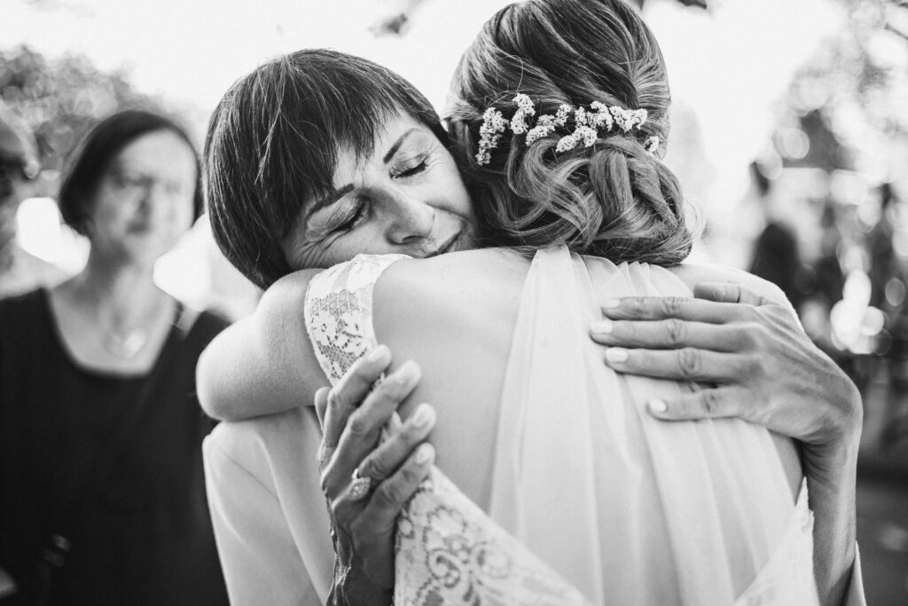 La maman de la mariée fait un câlin à sa fille à la sortie de la mairie.