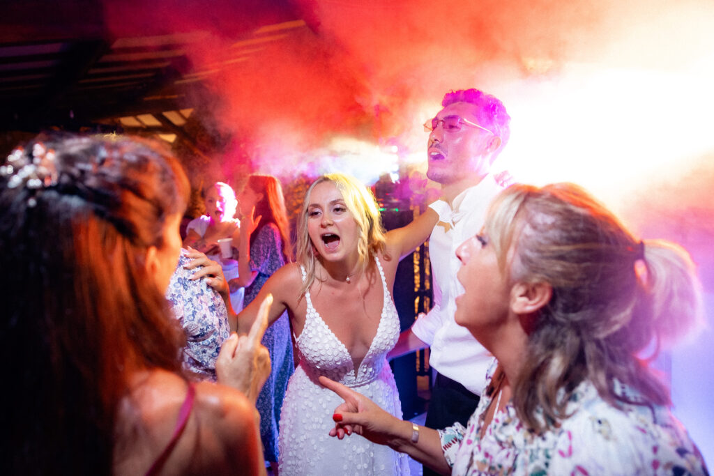 Les mariés et leurs invités chantent sur le dancefloor pendant la soirée.
