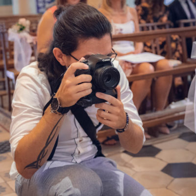 photographe-de-mariage-Aurélien-Kirchner Aurélien Kirchner avec un appareil photo en action pendant un mariage lors de la cérémonie religieuse